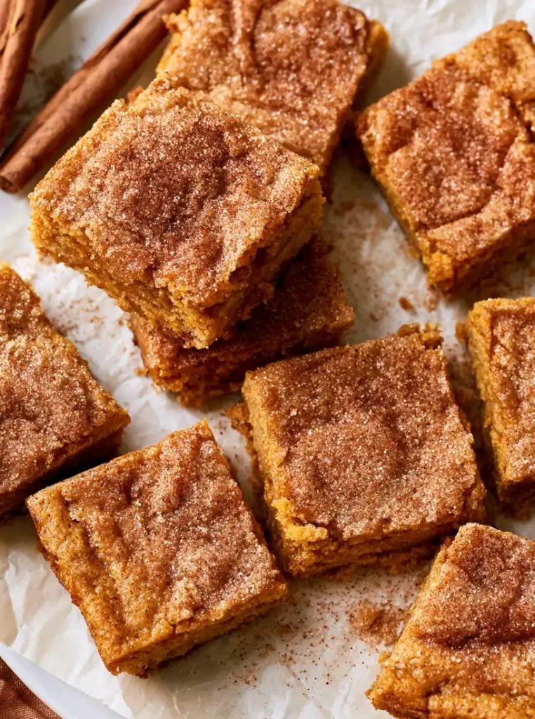 close up Brown Butter Pumpkin Snickerdoodle Bars, served on parchment paper